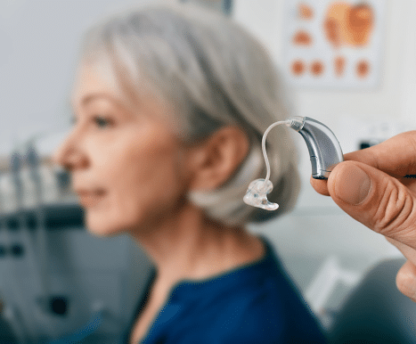 Audiologist getting a hearing aid fitted to their patient