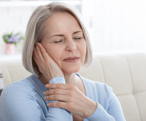 Woman in discomfort from tinnitus symptoms